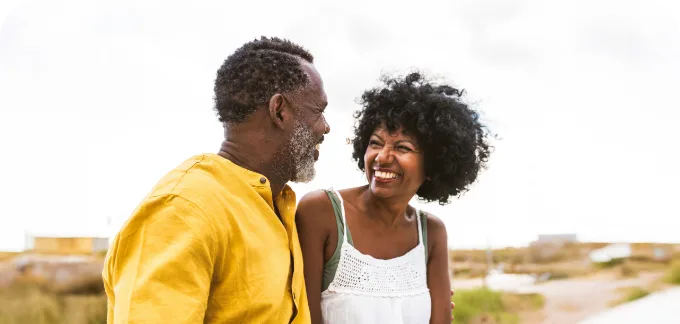 Couple outside smiling at each other near the beach