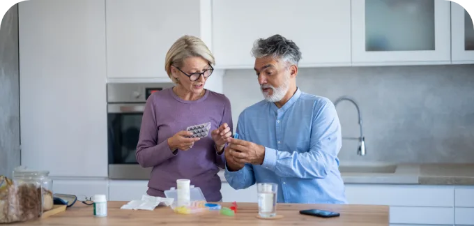 Older Couple in kitchen setting reviewing their medications
