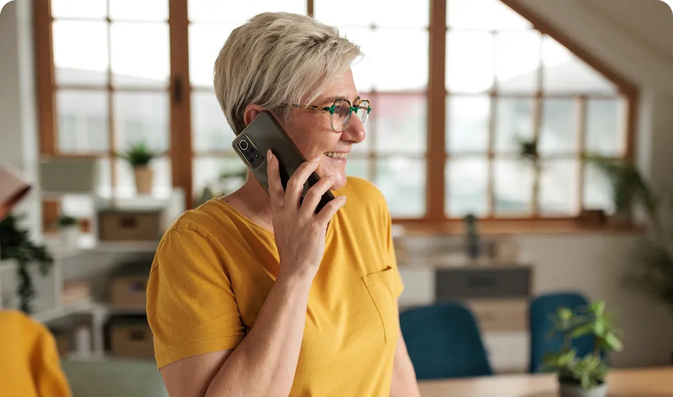 woman smiling & talking on a phone