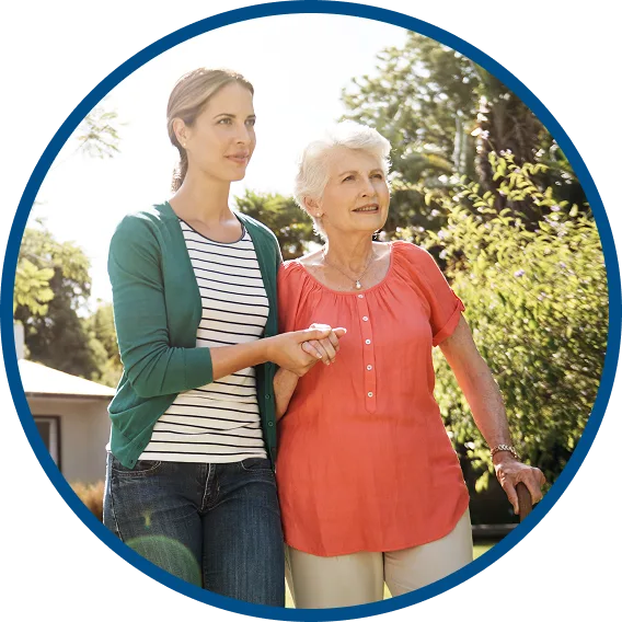 image shows a younger woman walking & supporting an older woman
