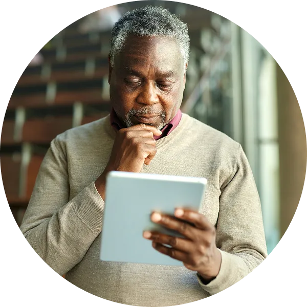 older man reading on a tablet