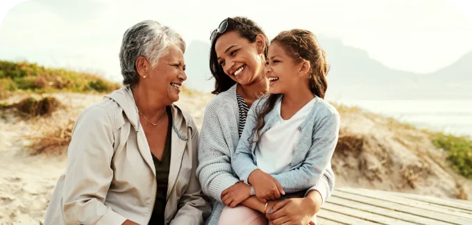 Grandmother smiling at daughter and granddaughter near the beach dunes
