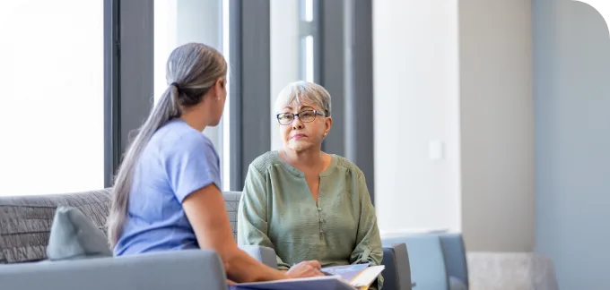Woman Patient sitting on couch with woman dr reviewing results on a tablet